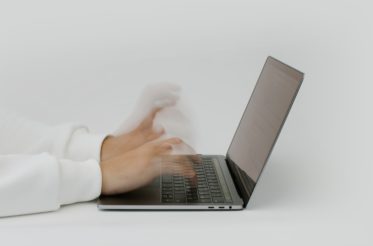 person typing fast on laptop